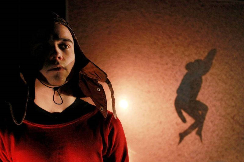 Miro Poutanen katsoo haaveksivasti eteen, takana dramaattinen valo ja hyppäävän hahmon varjo seinällä.