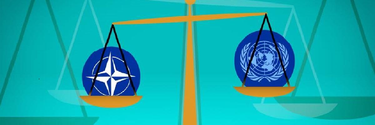 Naton ja YK:n logot vaakakupissa.